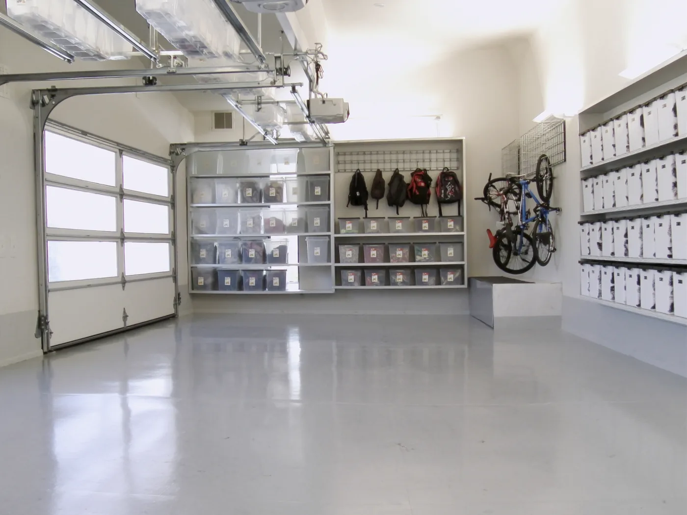 Organized garage after a Reset My Garage visit, with labeled bins and an epoxy floor