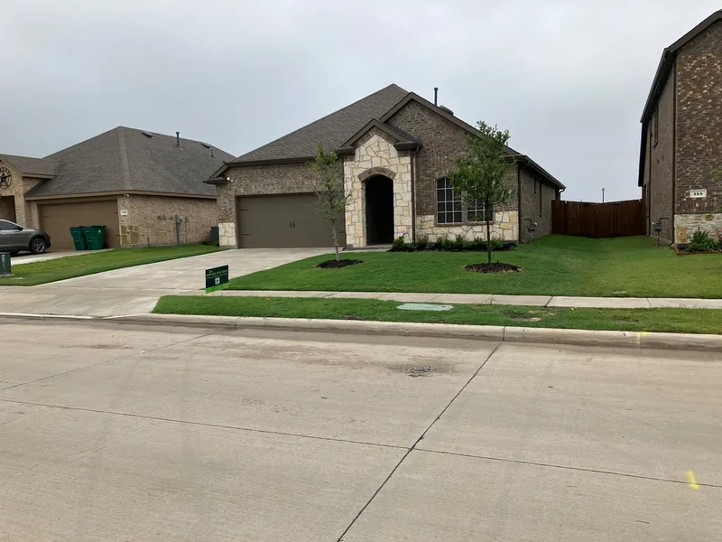 New-build home with a Mahalic and Sons yard sign and freshly installed sod